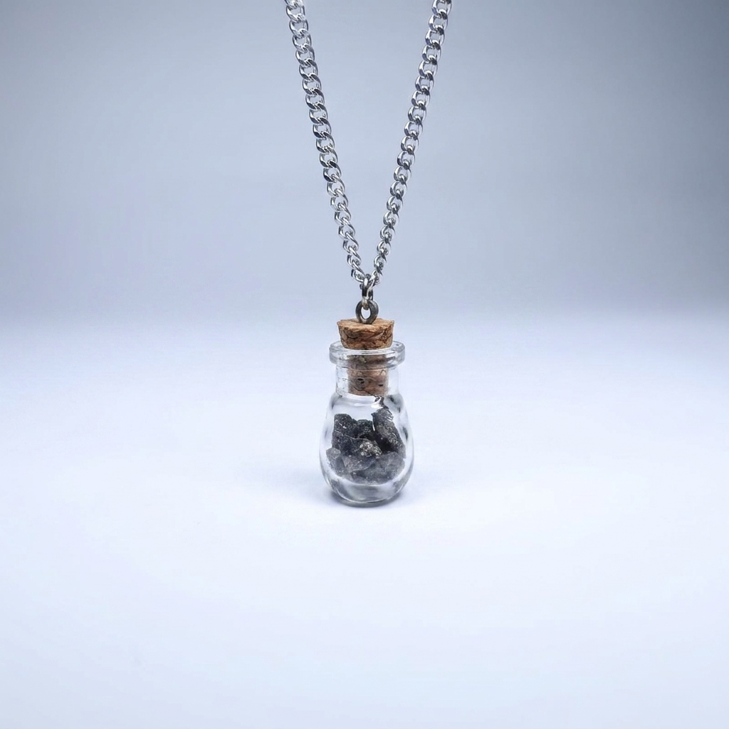 Āgāya Rasam meteorite vial pendant on silver chain, studio shot