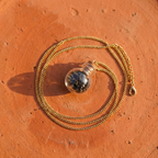 Sōma Maṇal gold — flat lay on terracotta tile