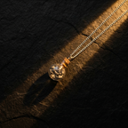 Anandham silver — flat lay on black stone with golden light streak